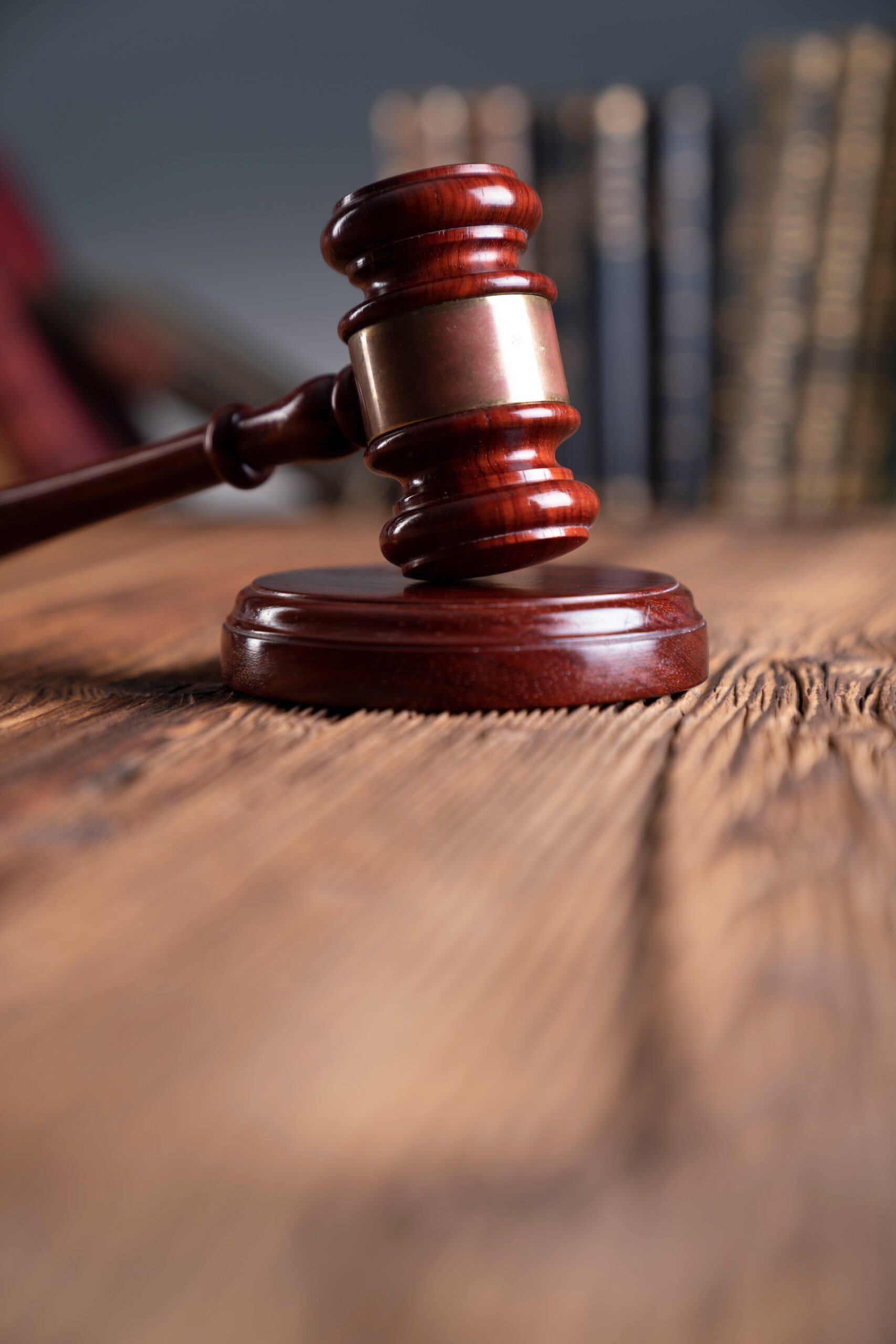 Law theme - judge office. Gavel and legal books on the judge desk. Two men in suits sit across from each other at a desk in a law office, discussing documents titled “Texas Child Support Guidelines.” Shelves of law books and a painting of scales of justice are visible in the background.